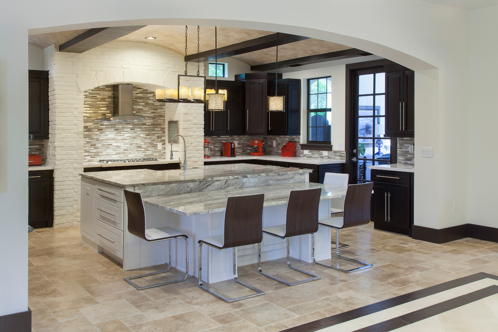 This is an example of a large contemporary single-wall open plan kitchen in Orlando with an integrated sink, flat-panel cabinets, dark wood cabinets, quartz benchtops, metallic splashback, metal splashback, stainless steel appliances, travertine floors and multiple islands.