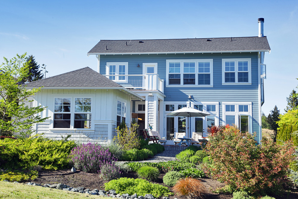 Inspiration for a beach style two-storey blue exterior in Seattle with mixed siding and a hip roof.