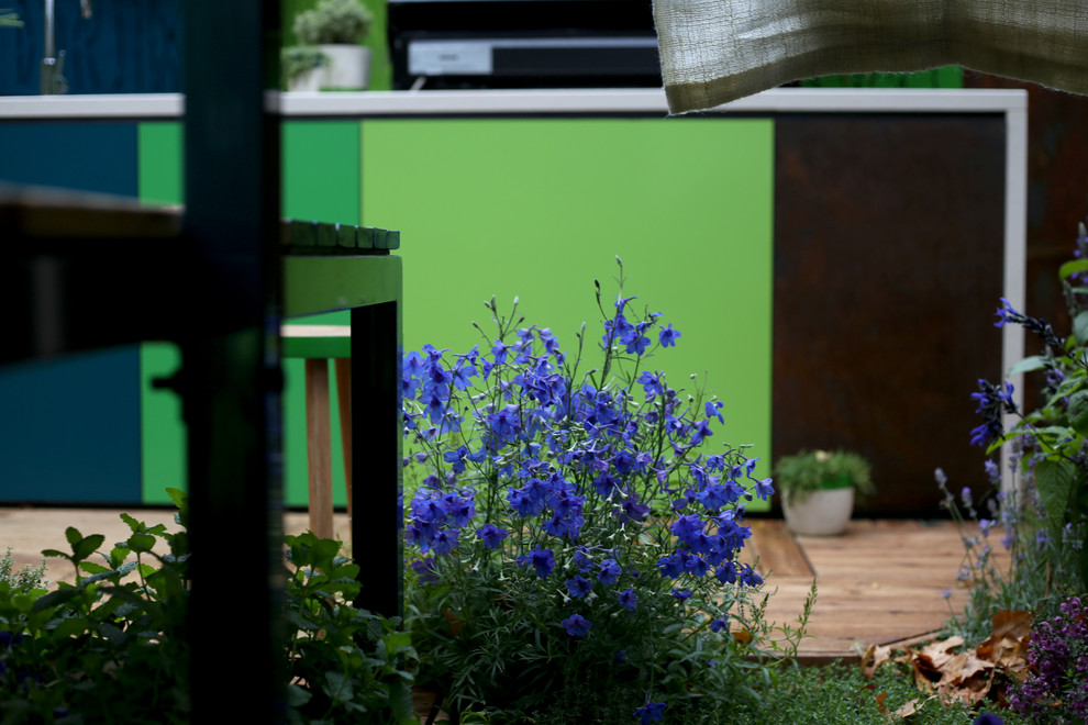 This is an example of an eclectic courtyard patio in Melbourne with an outdoor kitchen, decking and no cover.