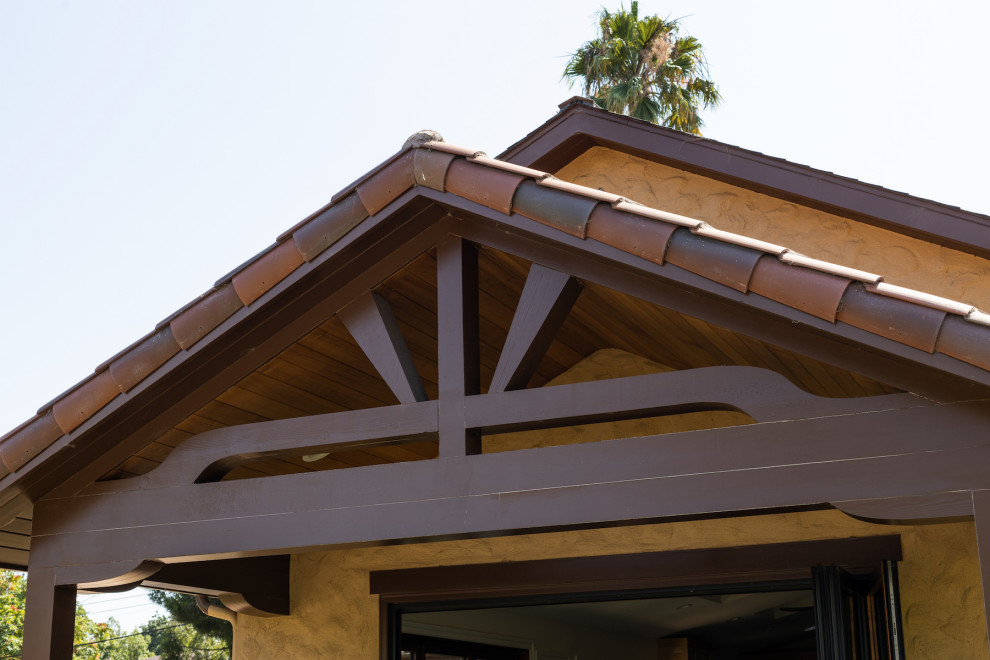 Inspiration pour une façade de maison bohème en stuc de plain-pied avec un toit en tuile.