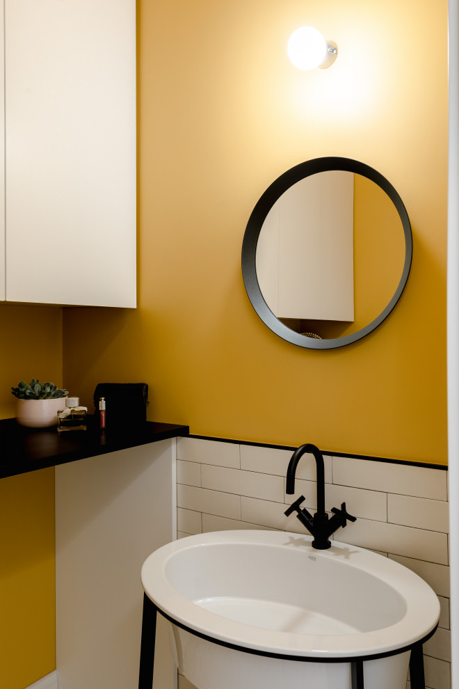 Idee per un piccolo bagno di servizio scandinavo con ante nere, piastrelle bianche, pareti gialle, pavimento multicolore e mobile bagno freestanding