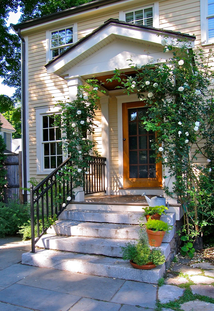 Photo of a small traditional front door in Boston with yellow walls, a single front door and a medium wood front door.