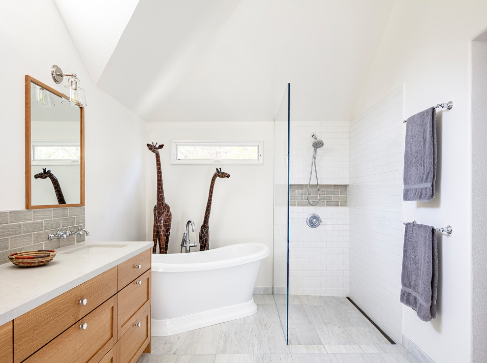 Design ideas for a transitional bathroom in San Francisco with shaker cabinets, medium wood cabinets, a freestanding tub, a curbless shower, white tile, subway tile, white walls, an undermount sink, grey floor, an open shower, grey benchtops, a niche, a double vanity, a built-in vanity and vaulted.