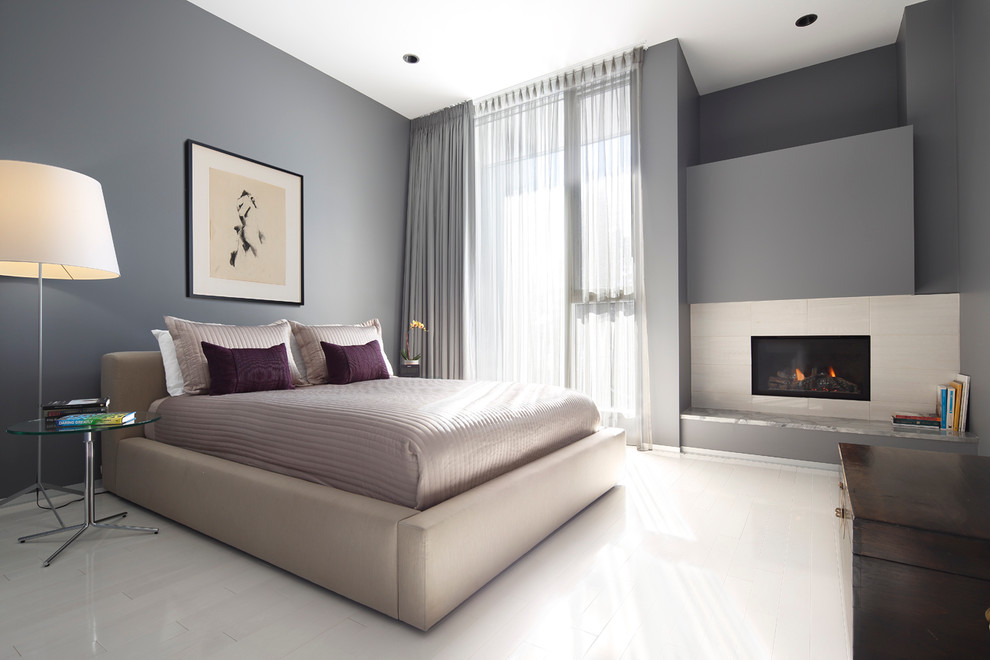Inspiration for a contemporary bedroom in Calgary with grey walls, painted wood floors, a ribbon fireplace and white floor.