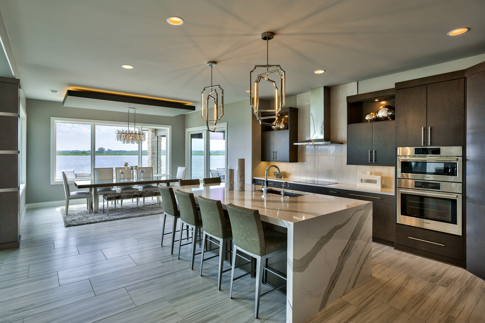 Contemporary galley eat-in kitchen in Omaha with an undermount sink, stainless steel appliances, with island, flat-panel cabinets, dark wood cabinets and white splashback.