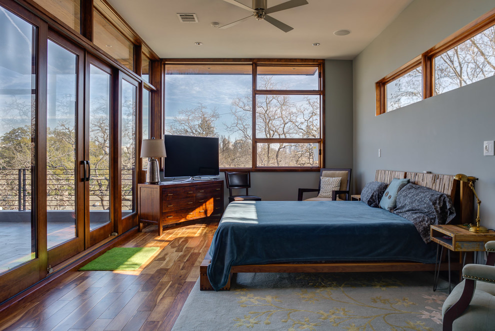 Inspiration for a large contemporary master bedroom in Austin with medium hardwood floors, grey walls and no fireplace.
