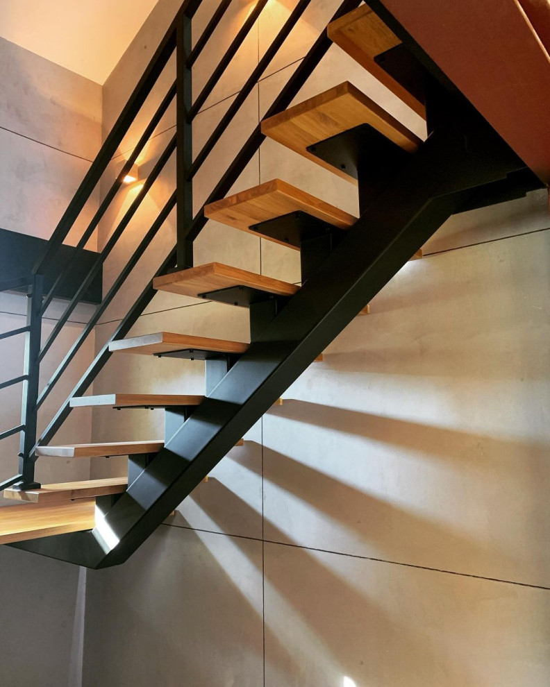 Cette photo montre un escalier tendance en U de taille moyenne avec des marches en bois, des contremarches en bois et un garde-corps en métal.