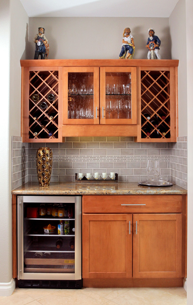 Design ideas for a small contemporary single-wall wet bar in San Diego with shaker cabinets, medium wood cabinets, granite benchtops, grey splashback, subway tile splashback and travertine floors.