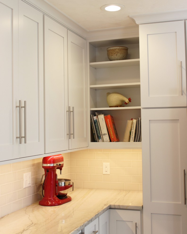 Example of a large transitional u-shaped light wood floor eat-in kitchen design in Chicago with an undermount sink, flat-panel cabinets, white cabinets, granite countertops, beige backsplash, subway tile backsplash and stainless steel appliances