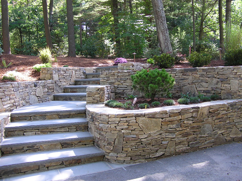 Design ideas for a traditional sloped garden in Boston with natural stone pavers.