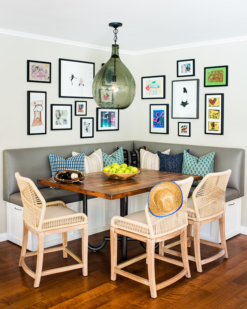 Eclectic dining room in Los Angeles with white walls, medium hardwood floors and brown floor.