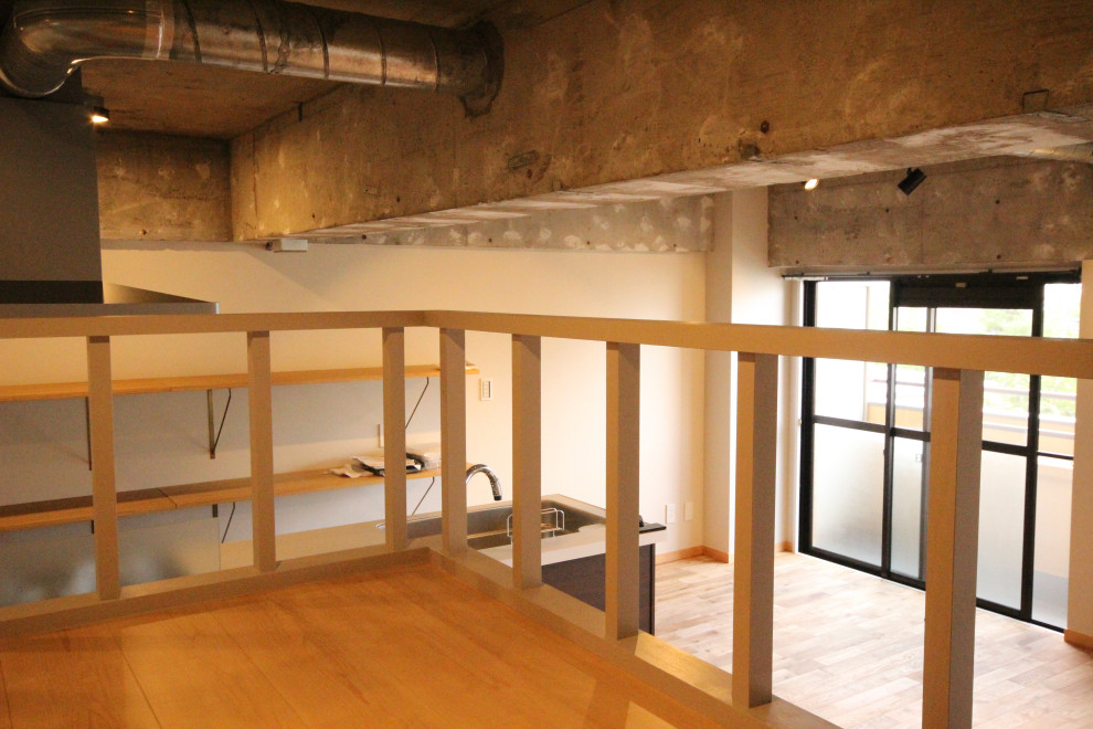 Modelo de salón tipo loft de estilo zen con paredes blancas, suelo de madera en tonos medios, suelo beige, vigas vistas y papel pintado