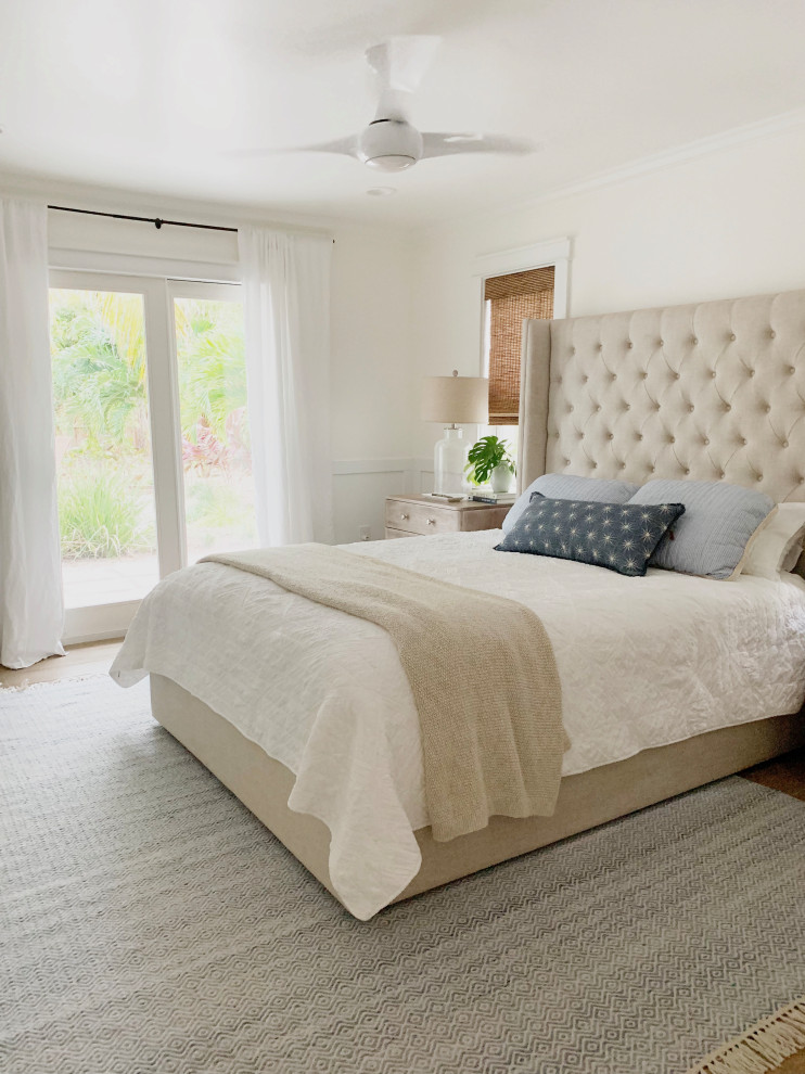 Mid-sized beach style master bedroom in Orlando with white walls, medium hardwood floors and brown floor.