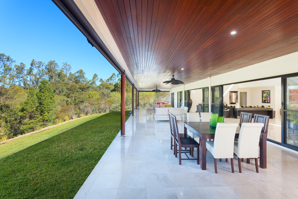 Photo of an expansive contemporary backyard patio in Brisbane with tile and a roof extension.