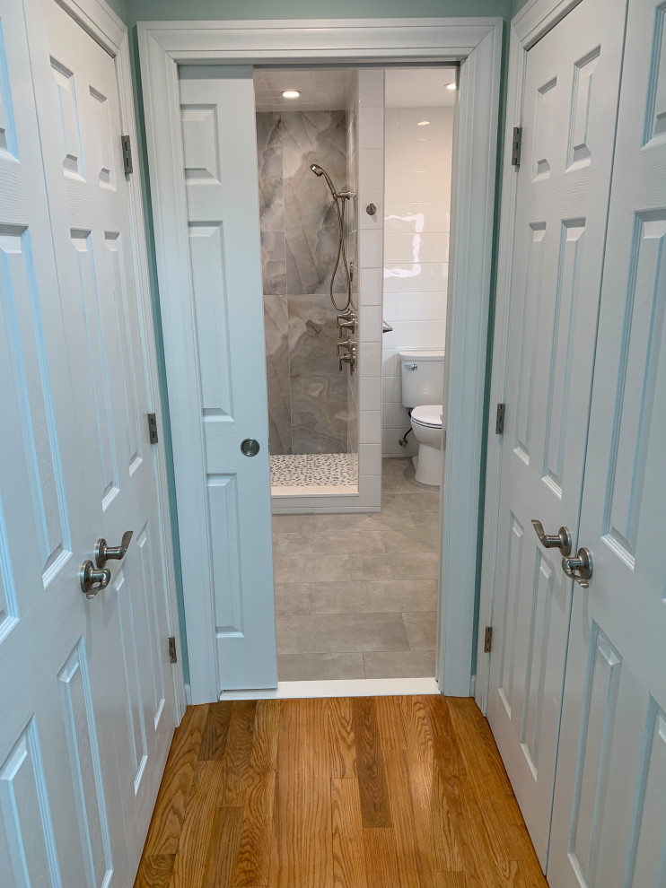 Photo of a coastal bathroom in Other with freestanding cabinets, green cabinets, a walk-in shower, a two-piece toilet, white tiles, ceramic tiles, engineered stone worktops, grey floors, a sliding door, white worktops, a shower bench, double sinks and a freestanding vanity unit.