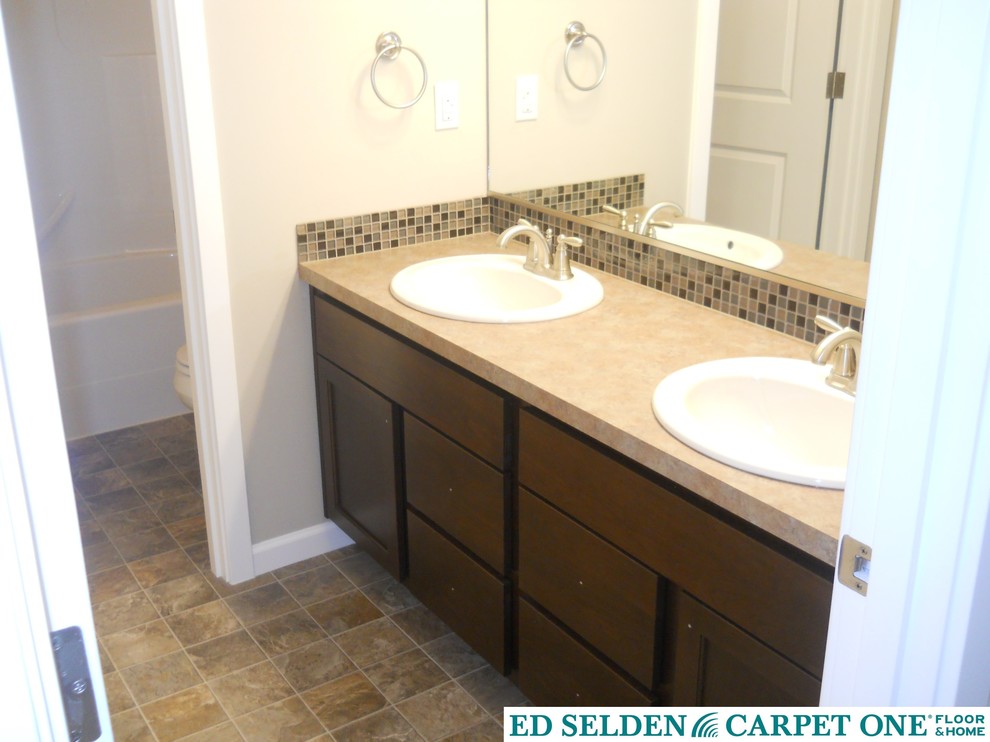 Example of a mid-sized transitional master multicolored tile and mosaic tile vinyl floor alcove bathtub design in Seattle with a drop-in sink, laminate countertops, beige walls, flat-panel cabinets and dark wood cabinets
