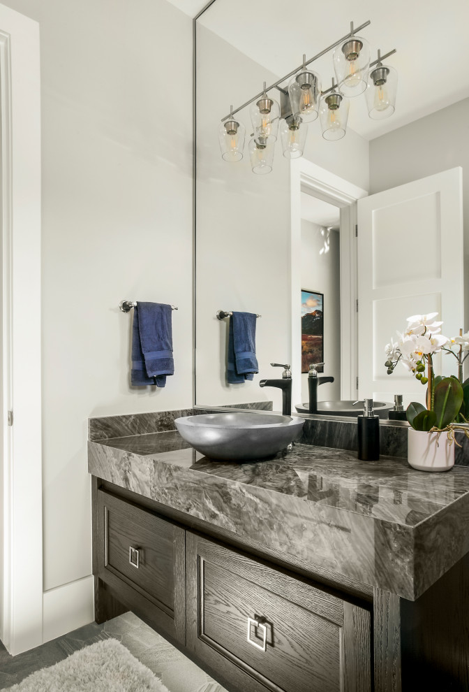 This is an example of a mid-sized transitional powder room in Salt Lake City with recessed-panel cabinets, brown cabinets, onyx benchtops, grey benchtops and a floating vanity.
