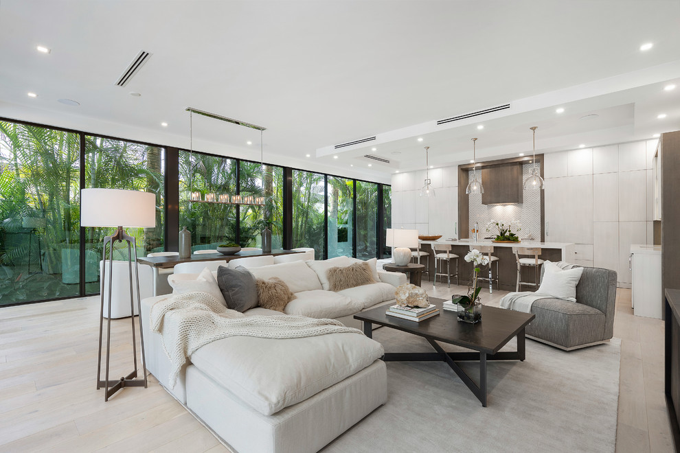 Photo of a contemporary living room in Miami with white walls, light hardwood floors and beige floor.