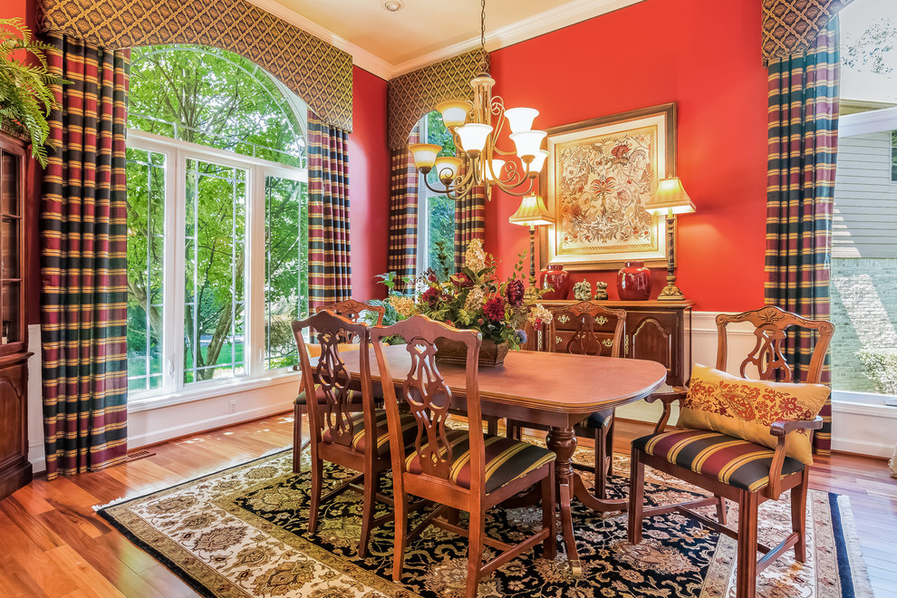 Inspiration for a timeless medium tone wood floor dining room remodel in Orange County with red walls