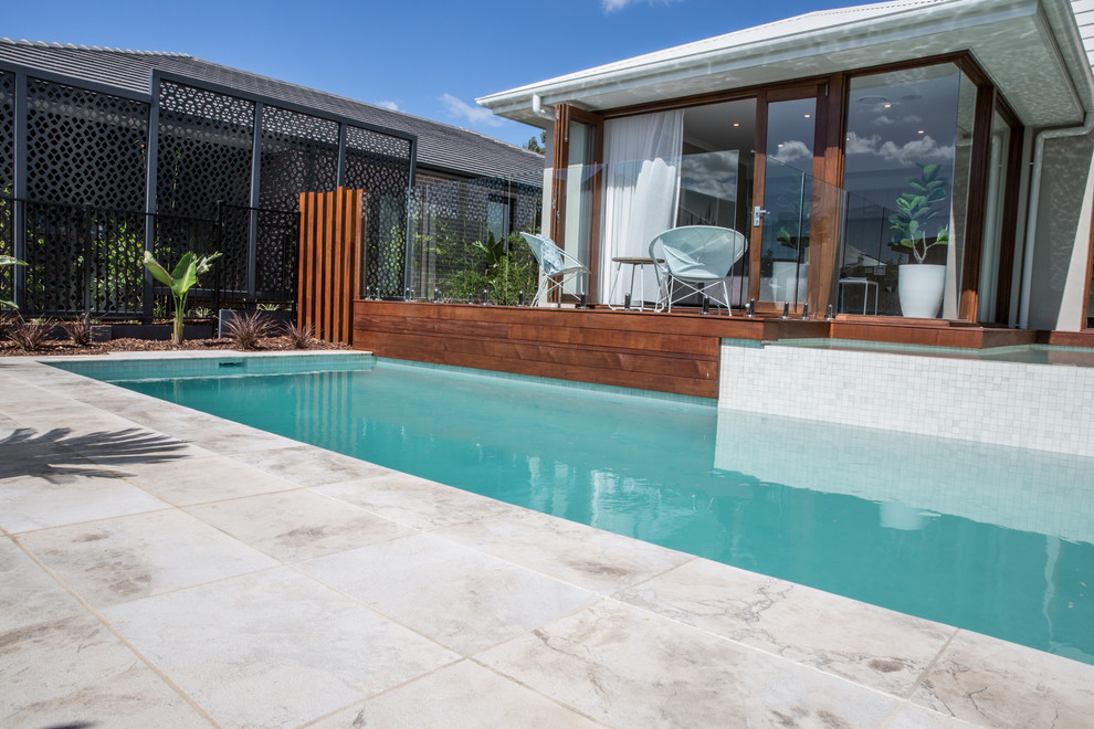 This is an example of a mid-sized contemporary backyard rectangular lap pool in Sydney with natural stone pavers.
