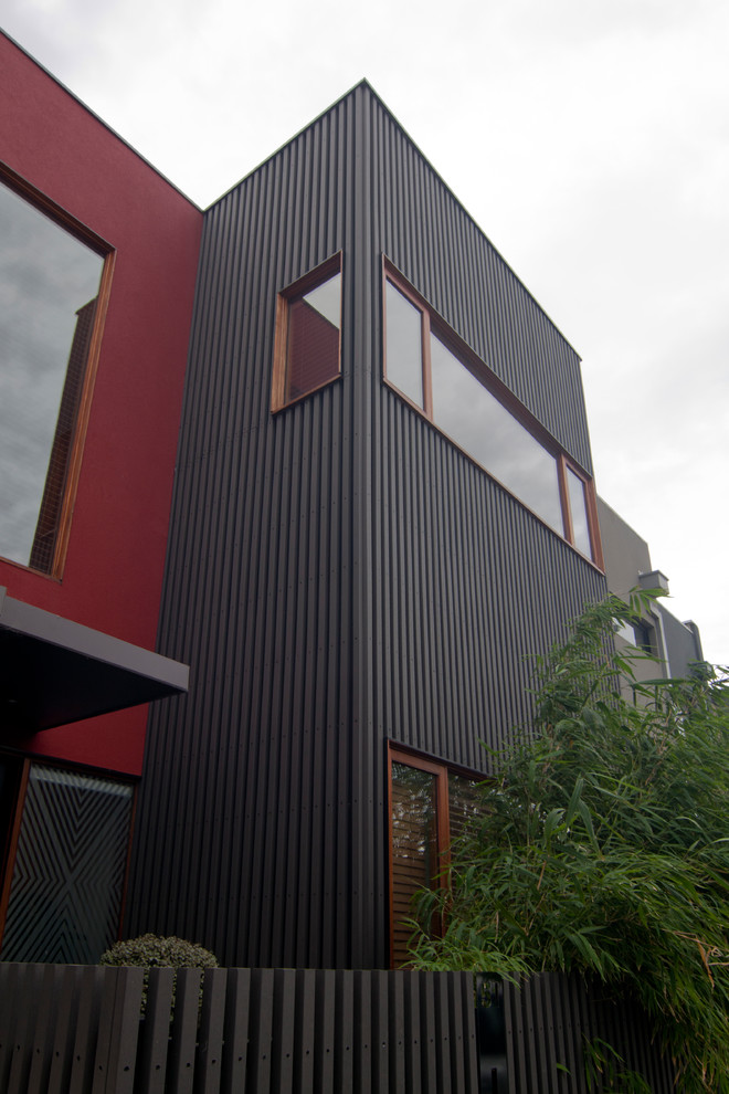 Inspiration for a small two-storey red house exterior in Melbourne with mixed siding.