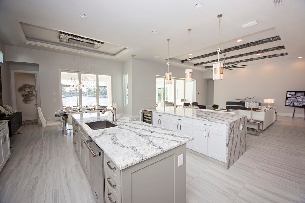 Photo of a large modern galley eat-in kitchen in Miami with an undermount sink, recessed-panel cabinets, grey cabinets, grey splashback, stone slab splashback, stainless steel appliances, marble floors, multiple islands and marble benchtops.