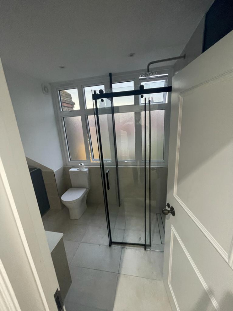 Photo of a medium sized retro bathroom in London with recessed-panel cabinets, grey cabinets, grey tiles, mosaic tiles, white walls, ceramic flooring, marble worktops, grey floors, a sliding door, white worktops, a single sink and a built in vanity unit.