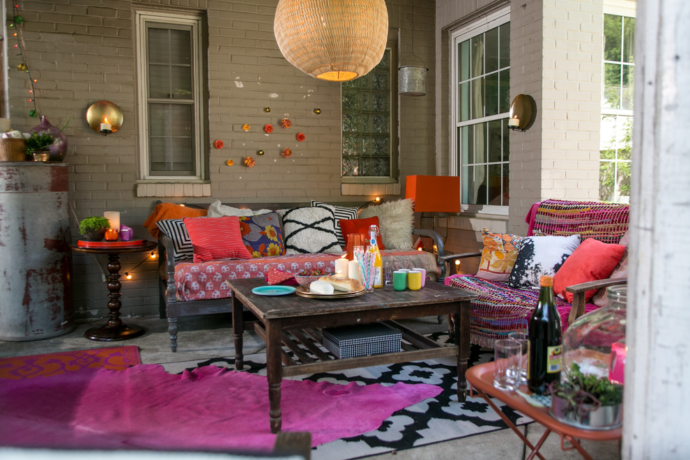 Design ideas for a small eclectic backyard patio in Raleigh with concrete slab and a roof extension.