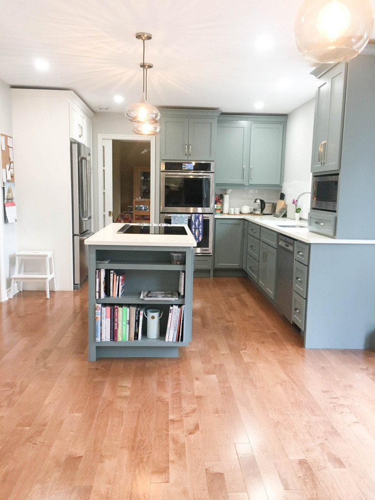 Enclosed kitchen - mid-sized transitional l-shaped medium tone wood floor and brown floor enclosed kitchen idea with a double-bowl sink, shaker cabinets, gray cabinets, quartz countertops, white backsplash, porcelain backsplash, stainless steel appliances, an island and white countertops