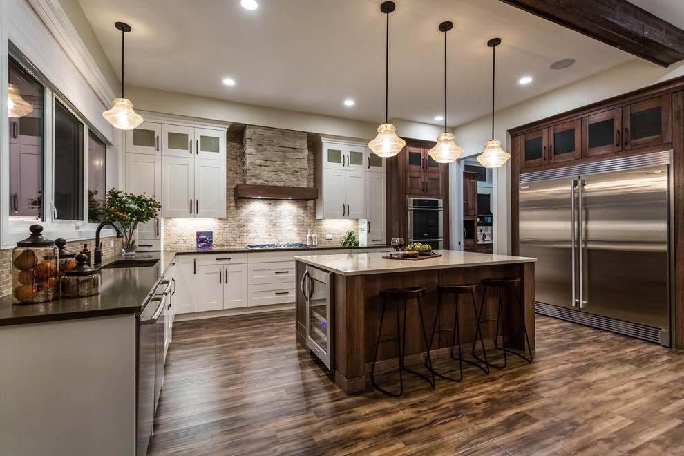 Large transitional u-shaped dark wood floor eat-in kitchen photo in Calgary with an undermount sink, shaker cabinets, white cabinets, quartz countertops, brown backsplash, ceramic backsplash, stainless steel appliances and an island