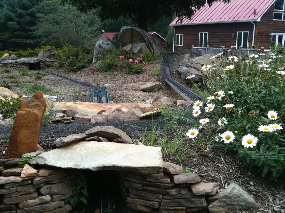 Design ideas for a large rustic partial sun backyard stone formal garden for summer.
