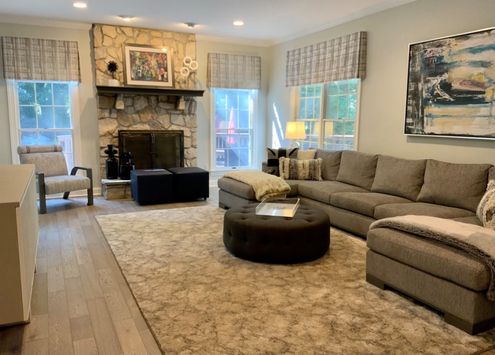 Inspiration for a medium sized contemporary enclosed games room in New York with grey walls, medium hardwood flooring, a standard fireplace, a stone fireplace surround, a wall mounted tv and grey floors.
