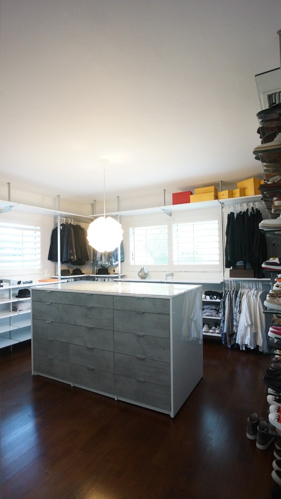 This is an example of a large modern gender-neutral dressing room in Miami with open cabinets, white cabinets and bamboo floors.