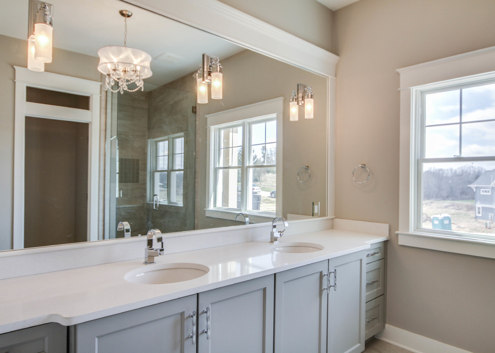 Inspiration for a large arts and crafts master bathroom in Grand Rapids with an undermount sink, recessed-panel cabinets, grey cabinets, engineered quartz benchtops, an alcove shower, gray tile and beige walls.