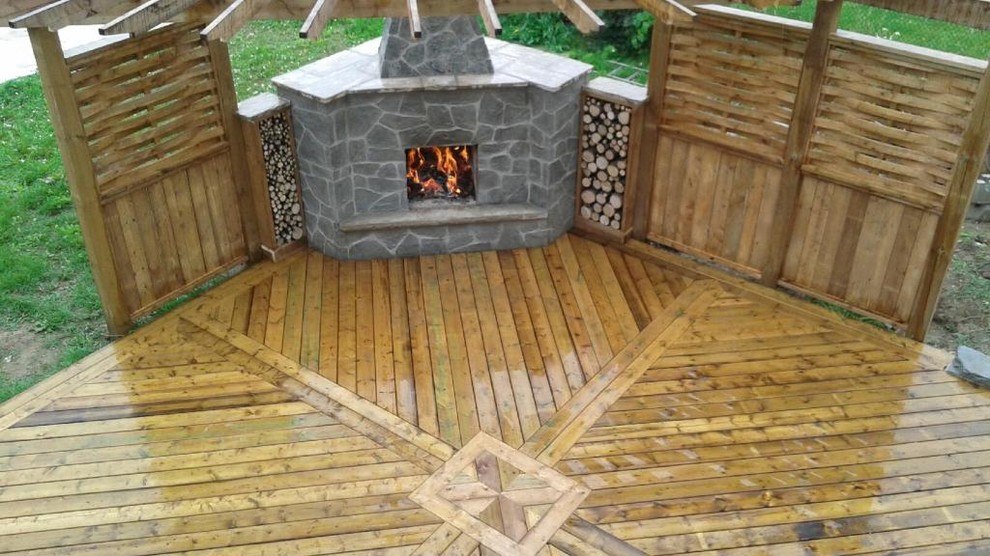 Example of a mid-sized mountain style backyard deck design in Toronto with a pergola