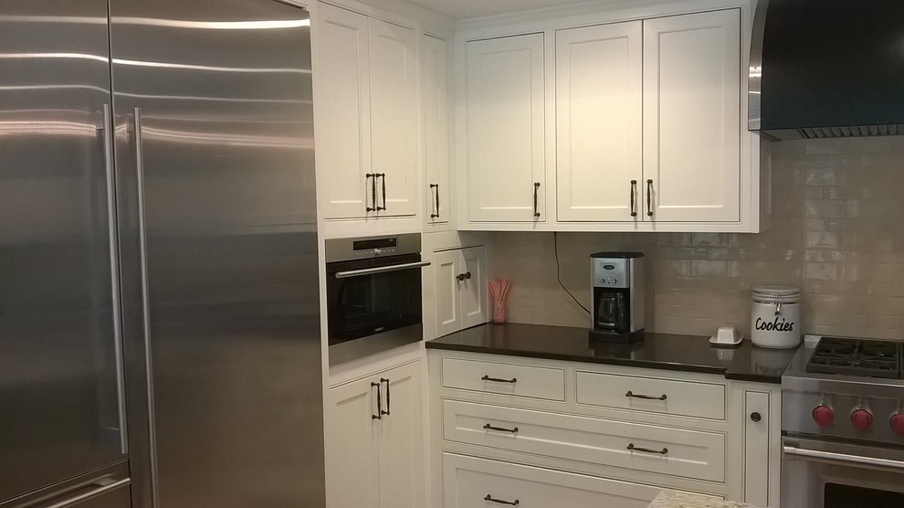 Kitchen - transitional kitchen idea in Minneapolis with recessed-panel cabinets, white cabinets, granite countertops and beige backsplash