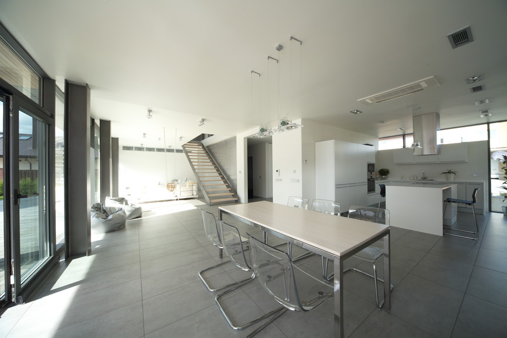 This is an example of a modern l-shaped eat-in kitchen in Other with flat-panel cabinets and white cabinets.