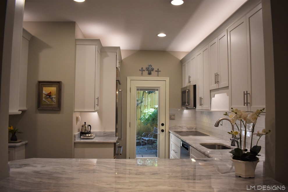 Example of a transitional l-shaped slate floor and green floor eat-in kitchen design with an undermount sink, shaker cabinets, white cabinets, quartzite countertops, white backsplash, glass tile backsplash, stainless steel appliances, no island and gray countertops