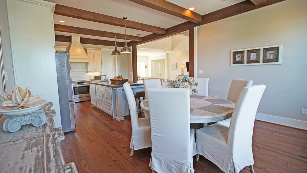 Photo of a country kitchen/dining combo in Other with white walls, medium hardwood floors, no fireplace and brown floor.