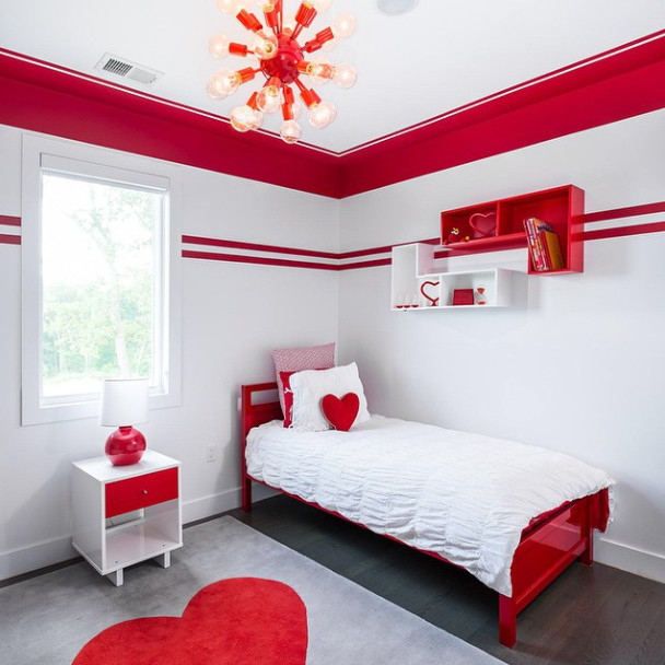 Modern master bedroom in New York with red walls and dark hardwood floors.