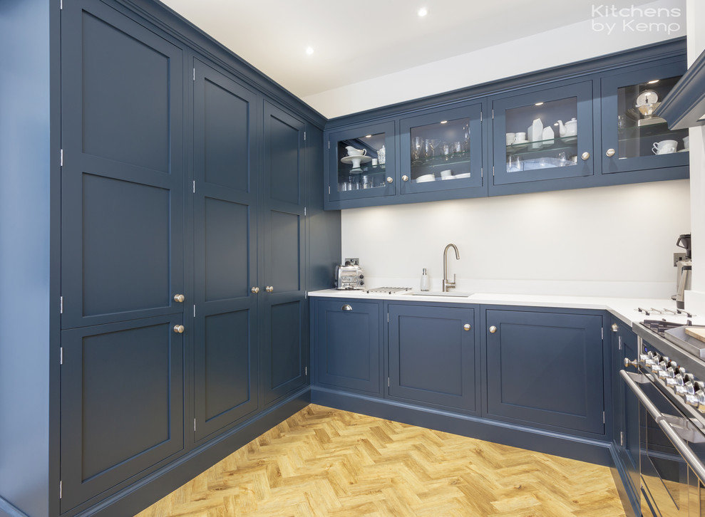 Design ideas for a mid-sized transitional u-shaped open plan kitchen in Cheshire with a single-bowl sink, blue cabinets, quartzite benchtops, blue splashback, marble splashback, stainless steel appliances, vinyl floors, a peninsula, white benchtop and shaker cabinets.