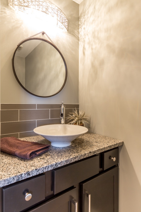 Photo of a small transitional powder room in Toronto with shaker cabinets, brown cabinets, a one-piece toilet, brown tile, porcelain tile and granite benchtops.