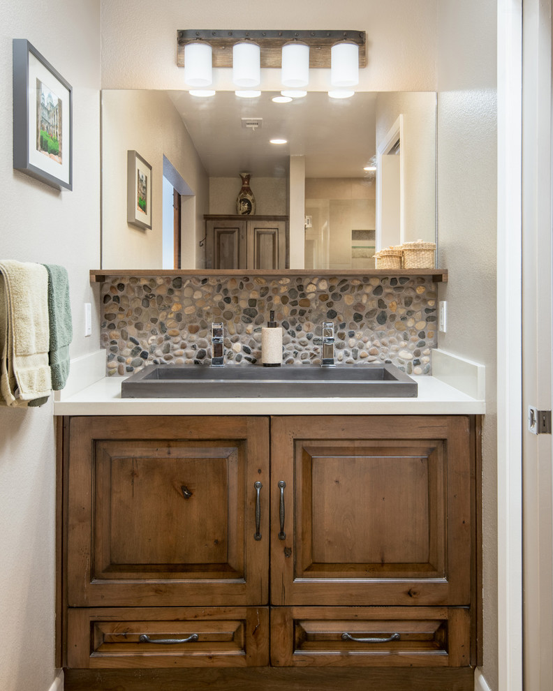 Large country master bathroom in San Diego with raised-panel cabinets, medium wood cabinets, a freestanding tub, an alcove shower, a one-piece toilet, brown tile, porcelain tile, brown walls, concrete floors, an undermount sink and engineered quartz benchtops.