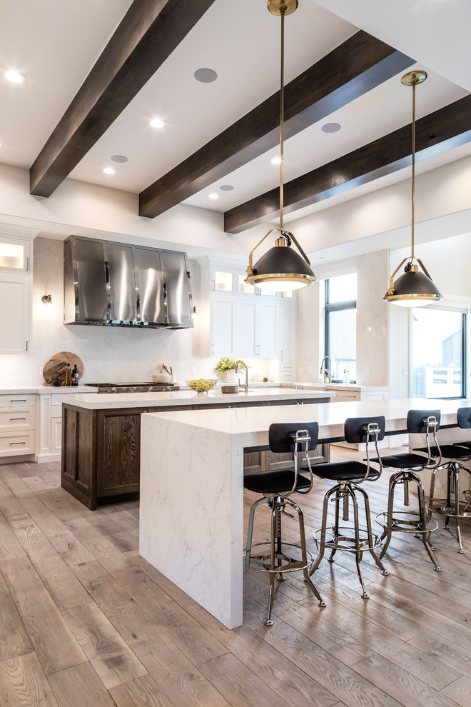 Inspiration for a large transitional galley eat-in kitchen in Salt Lake City with an undermount sink, recessed-panel cabinets, white cabinets, quartzite benchtops, white splashback, marble splashback, panelled appliances, light hardwood floors, multiple islands, beige floor and white benchtop.