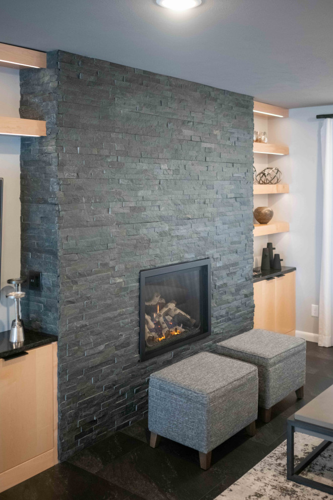 Inspiration for a large 1960s open concept vinyl floor and black floor living room remodel in Other with gray walls, a standard fireplace and a stone fireplace
