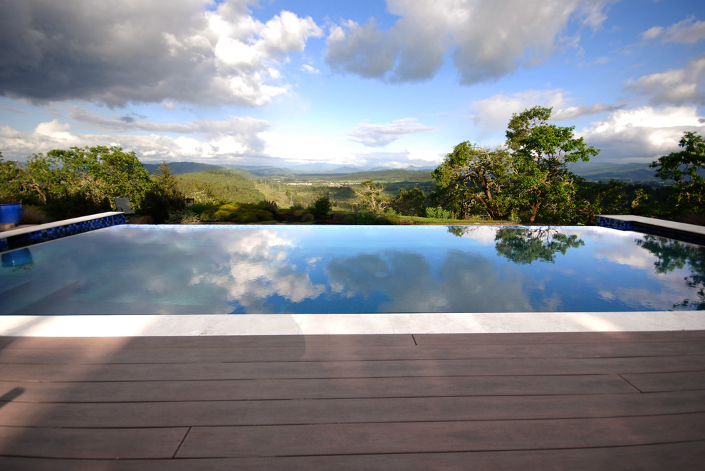 Inspiration for a large modern backyard rectangular infinity pool in Portland with concrete slab and with a pool.
