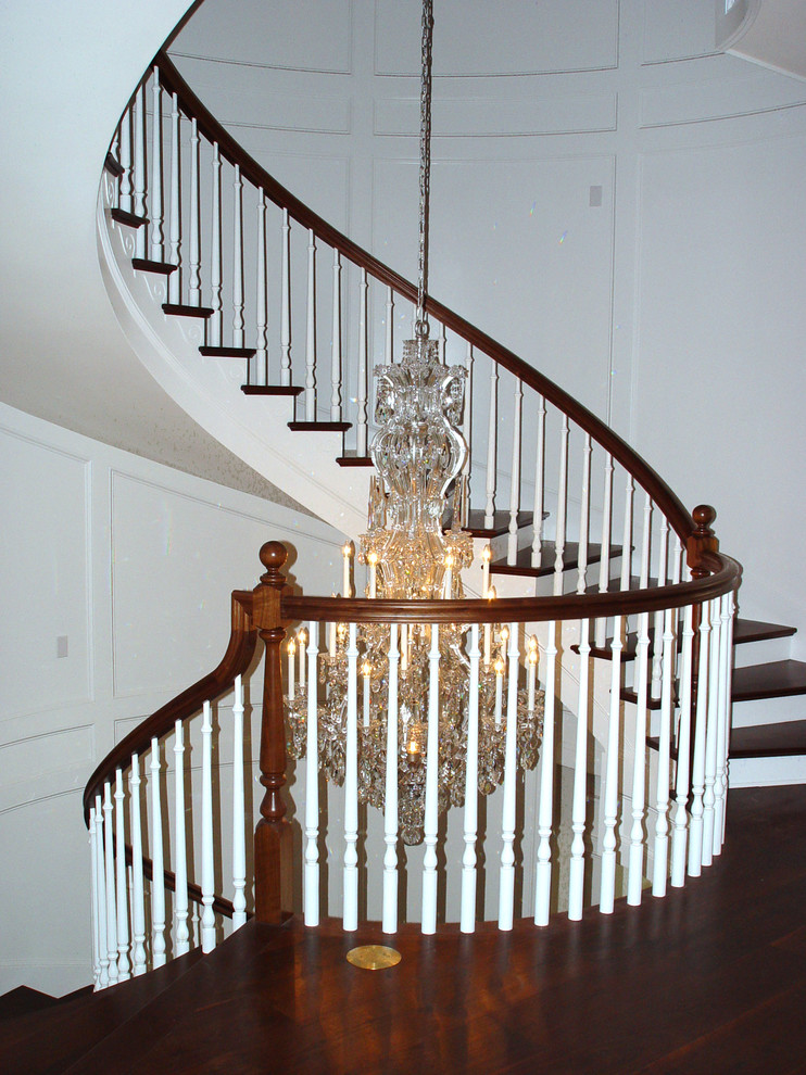 Inspiration for a large arts and crafts wood curved staircase in Cleveland with painted wood risers and wood railing.