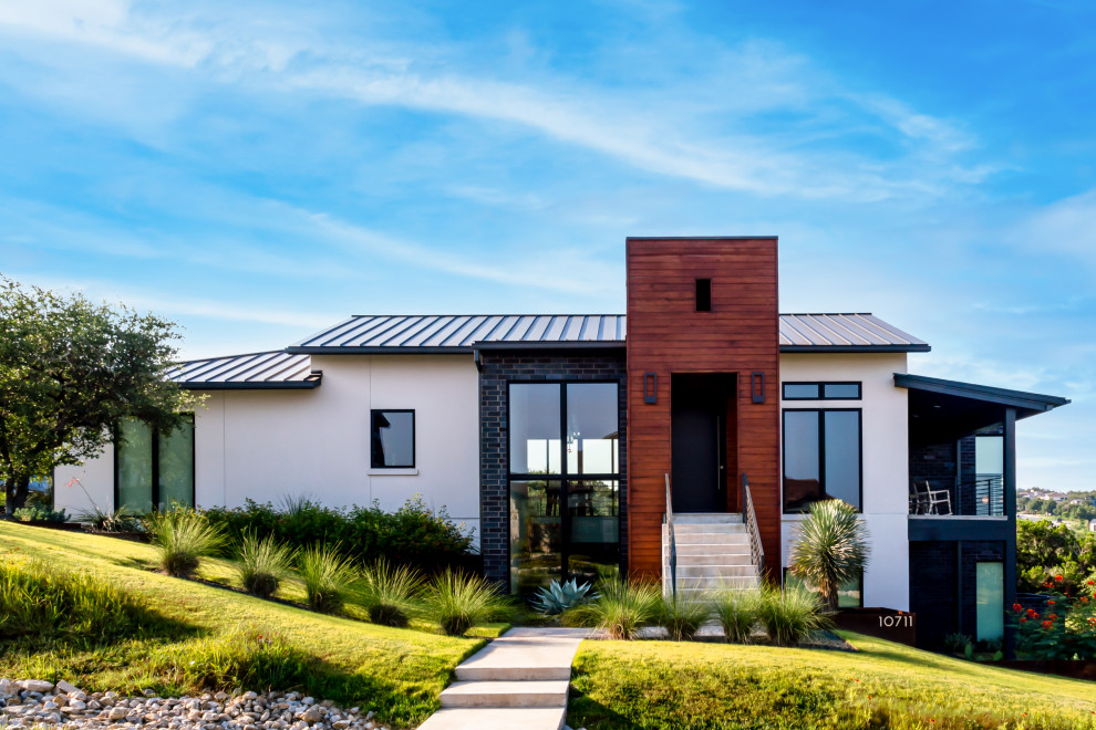 Zweistöckiges Modernes Einfamilienhaus mit weißer Fassadenfarbe, Satteldach, Blechdach und grauem Dach in Austin