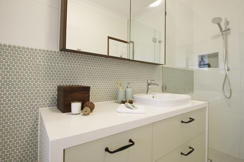 Inspiration for a small contemporary kids bathroom in Brisbane with flat-panel cabinets, green cabinets, a drop-in tub, a curbless shower, a two-piece toilet, white tile, mosaic tile, white walls, porcelain floors, a vessel sink, engineered quartz benchtops, beige floor, a hinged shower door and white benchtops.