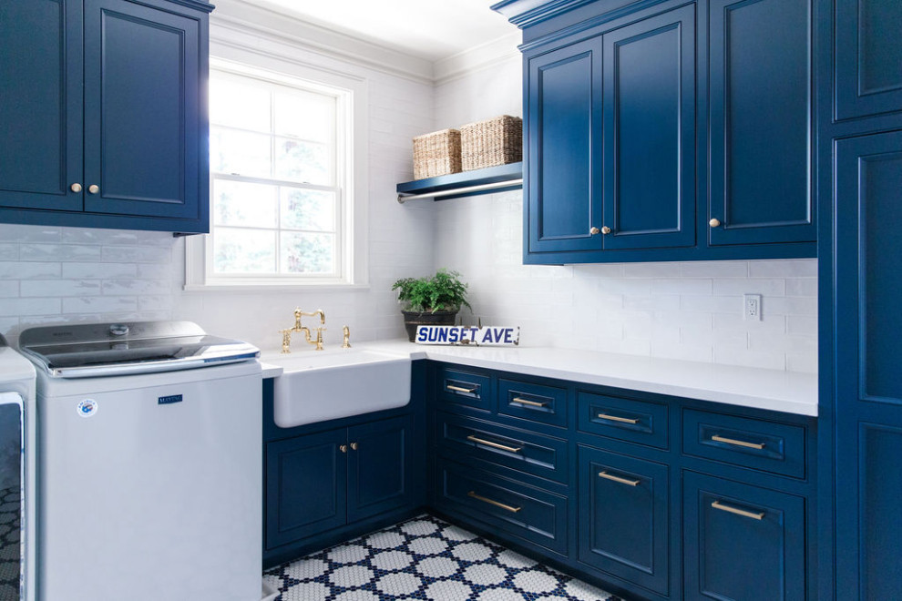 This is an example of a traditional l-shaped laundry room in Other with a farmhouse sink, recessed-panel cabinets, blue cabinets, a side-by-side washer and dryer, multi-coloured floor and white benchtop.